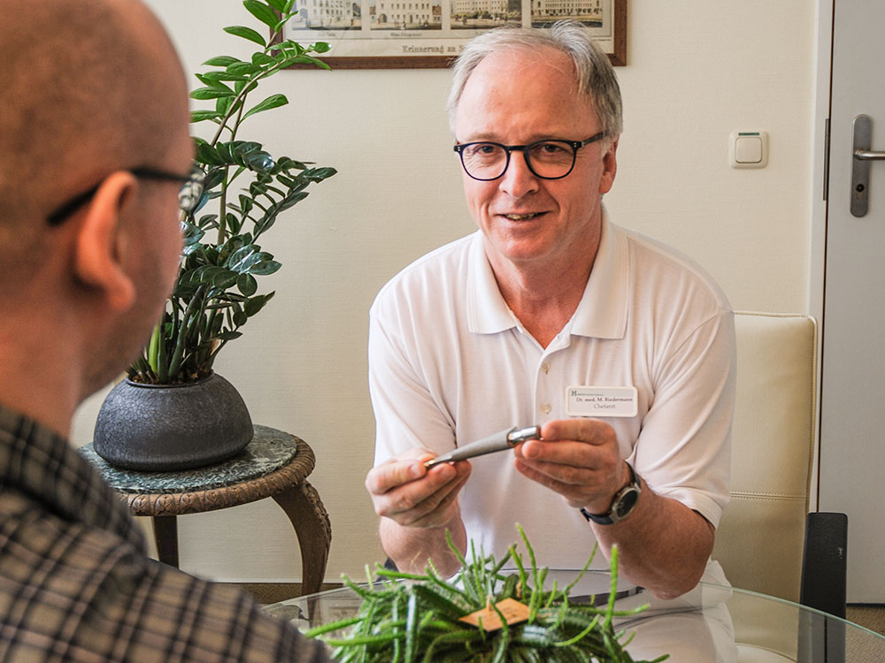 Dr. Biedermann erklärt vor einer Operation, wie die eingesetzte Prothese aussieht